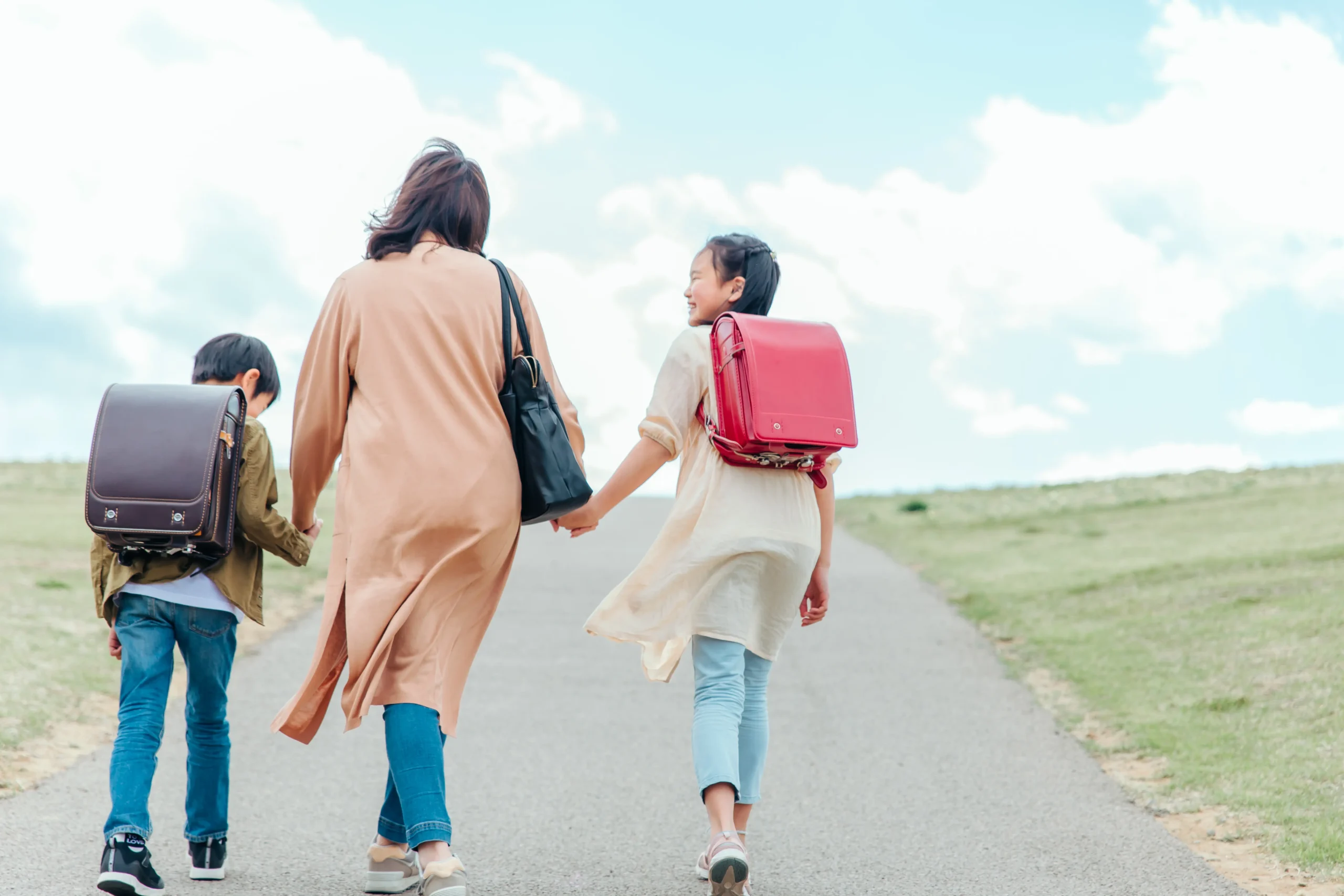 道を歩く親子の後ろ姿