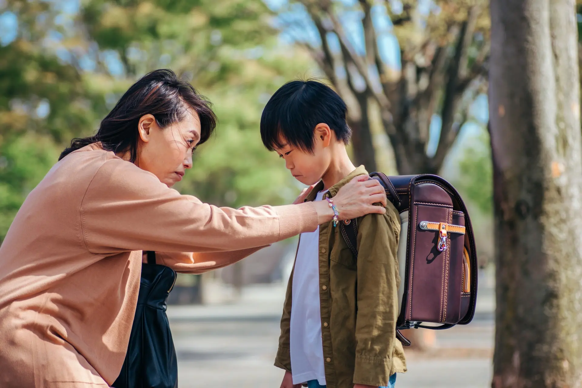 泣く小学生と心配する女性