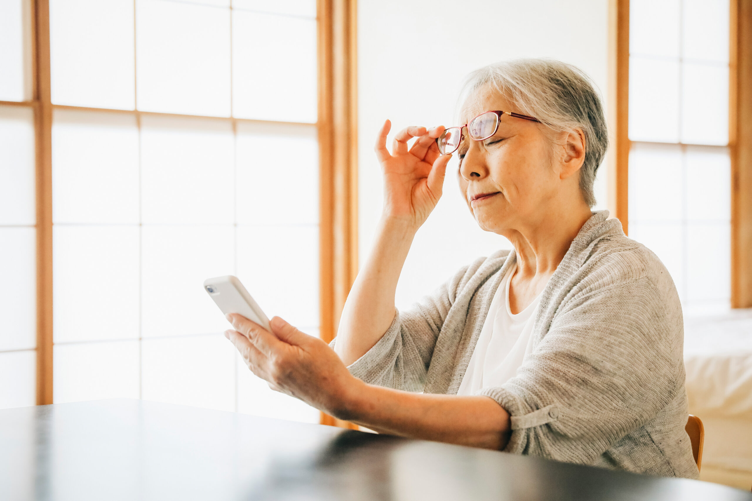 老眼鏡でスマホを見る女性