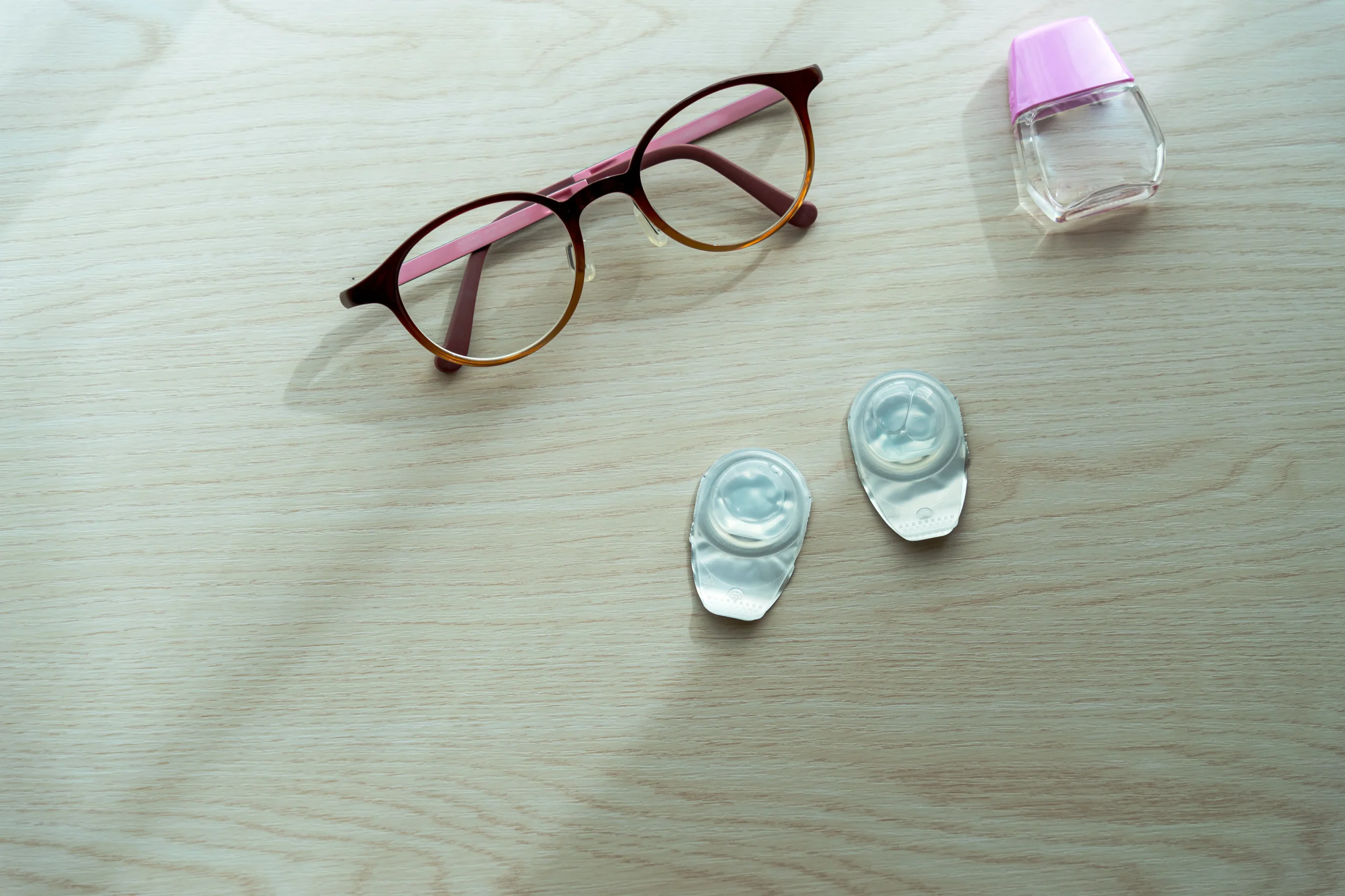 テーブルに置かれてメガネとコンタクトレンズ